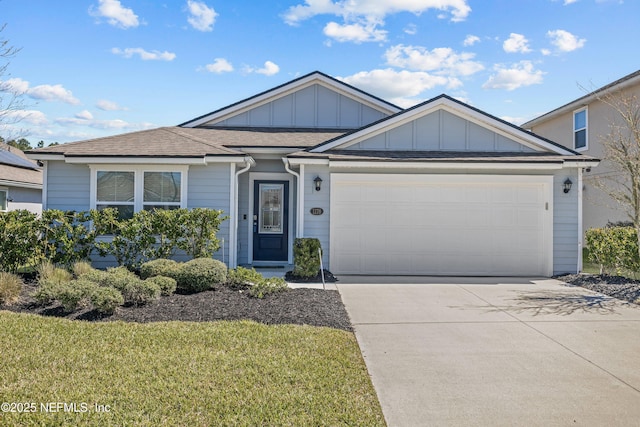 ranch-style house featuring a front yard, an attached garage, board and batten siding, and driveway