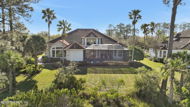 view of front of house with stucco siding, a tiled roof, and a front yard