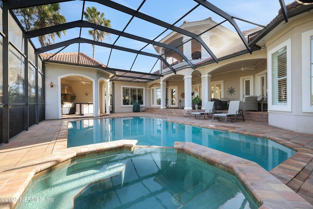 view of pool featuring a patio area, a lanai, a pool with connected hot tub, and ceiling fan