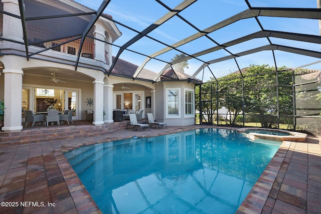 view of pool with a ceiling fan, glass enclosure, a patio area, and a pool with connected hot tub