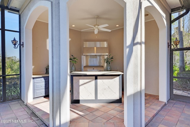 exterior space with arched walkways and a ceiling fan