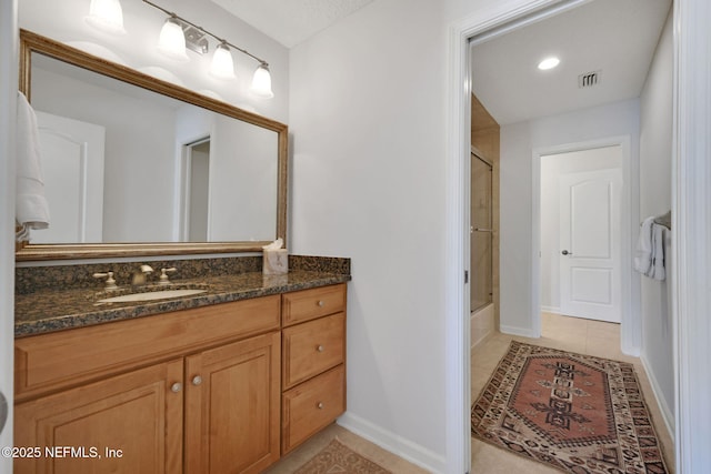 full bathroom featuring vanity, baseboards, visible vents, bath / shower combo with glass door, and tile patterned floors