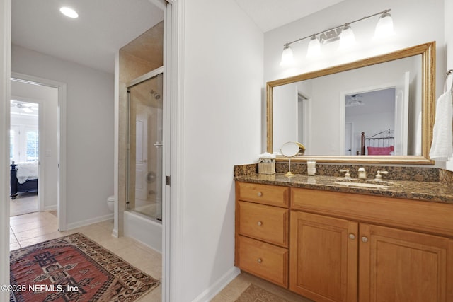 ensuite bathroom with baseboards, toilet, ensuite bathroom, tile patterned floors, and vanity