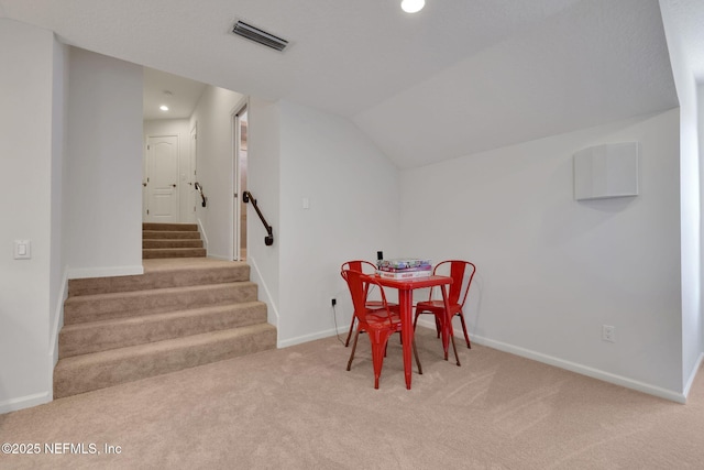 carpeted dining room featuring baseboards, visible vents, lofted ceiling, recessed lighting, and stairs