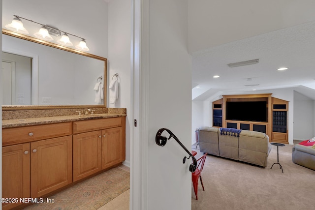 bathroom featuring recessed lighting, vanity, and vaulted ceiling