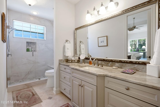 ensuite bathroom featuring vanity, a ceiling fan, a stall shower, ensuite bathroom, and toilet