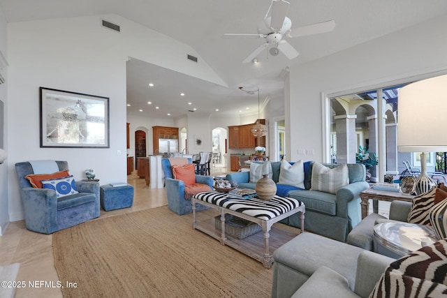 living area with visible vents, arched walkways, high vaulted ceiling, and ceiling fan