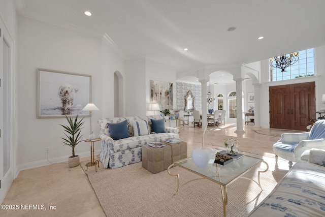 living area featuring crown molding, decorative columns, recessed lighting, and arched walkways