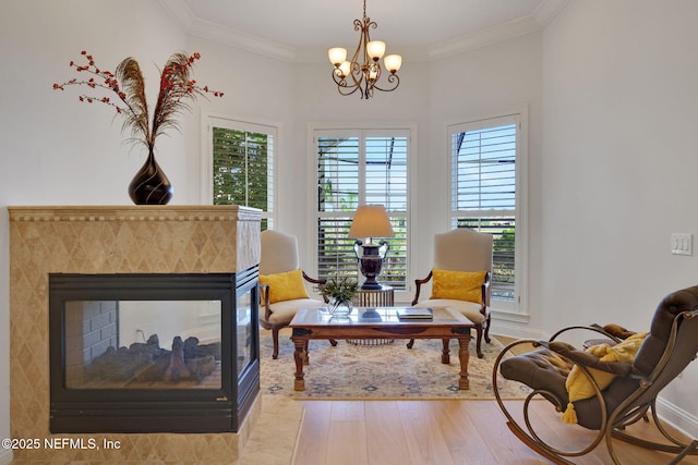 sitting room featuring a notable chandelier, ornamental molding, wood finished floors, baseboards, and a multi sided fireplace