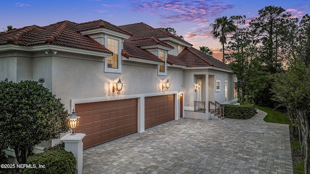 800 Hawks Nest Ct, Ponte Vedra Beach, FL 32082 - mediterranean / spanish-style home featuring a garage, decorative driveway, stucco siding, and a tile roof