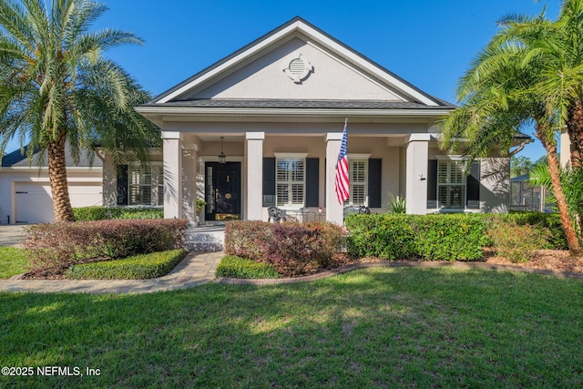 greek revival inspired property featuring stucco siding, an attached garage, covered porch, and a front yard