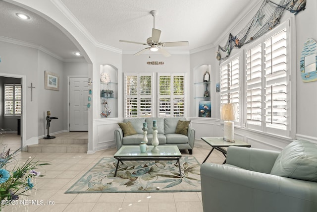 living room with a wealth of natural light, arched walkways, and a textured ceiling