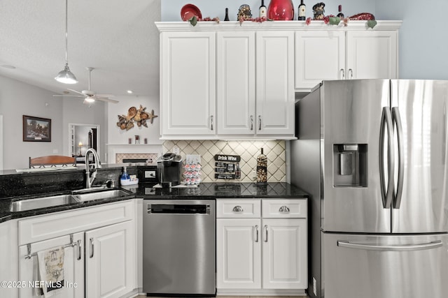 kitchen featuring a sink, stainless steel appliances, pendant lighting, white cabinetry, and backsplash