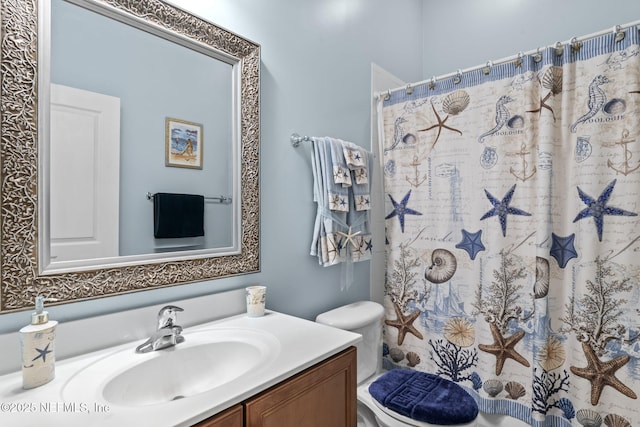 bathroom featuring toilet, vanity, and a shower with shower curtain