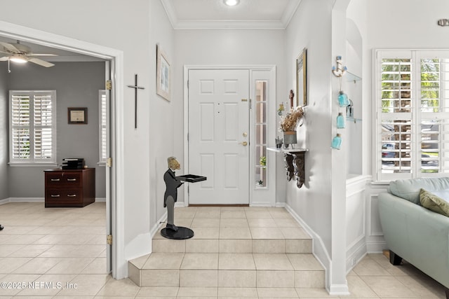 entryway with light tile patterned floors, arched walkways, baseboards, and ornamental molding