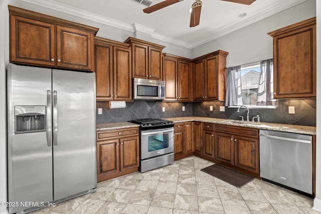 kitchen with a sink, tasteful backsplash, appliances with stainless steel finishes, crown molding, and light stone countertops