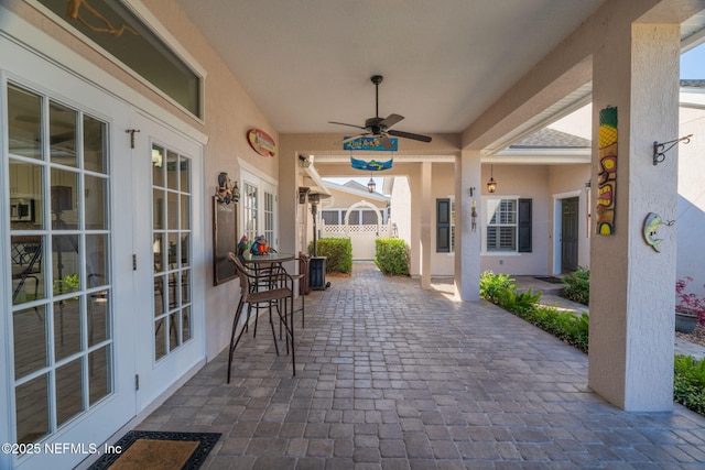 view of patio / terrace with french doors, a ceiling fan, and fence