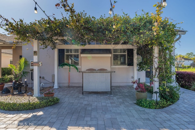 view of front of home with stucco siding and a patio