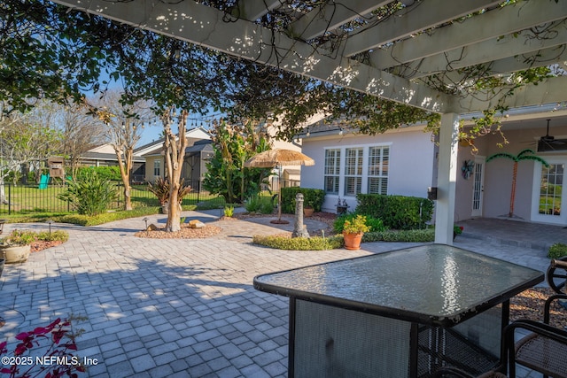 view of patio with a ceiling fan, a playground, and fence