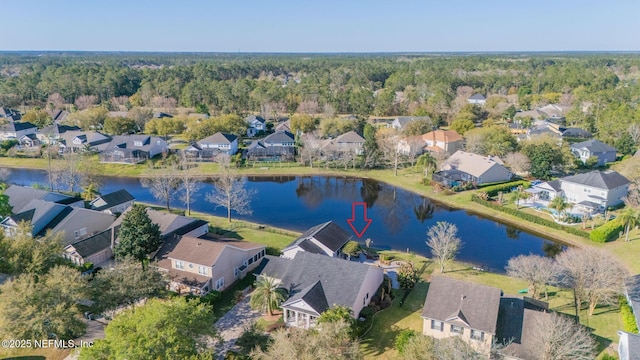 aerial view with a wooded view, a residential view, and a water view