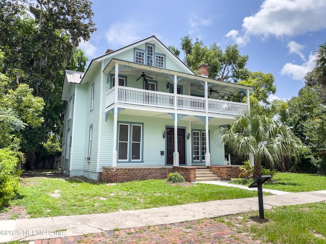 417 N 3rd St, Palatka, FL 32177 - view of front of house with a ceiling fan, a balcony, a chimney, and a porch
