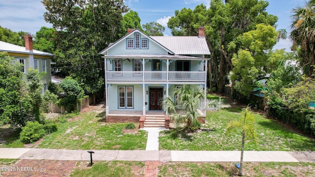 417 N 3rd St, Palatka, FL 32177 - view of front of home with a balcony, a porch, a chimney, and metal roof