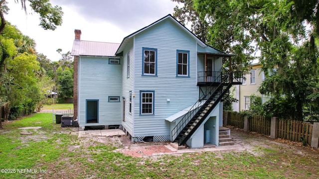 417 N 3rd St, Palatka, FL 32177 - rear view of house with stairway, metal roof, and a chimney