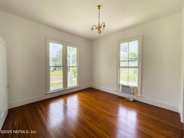 417 N 3rd St, Palatka, FL 32177 - unfurnished room featuring a chandelier, a wall mounted AC, dark wood-style flooring, and baseboards