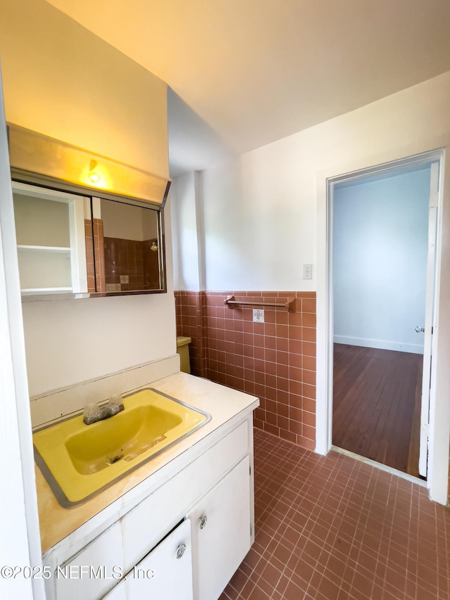 417 N 3rd St, Palatka, FL 32177 - bathroom with tile walls, vanity, and a wainscoted wall
