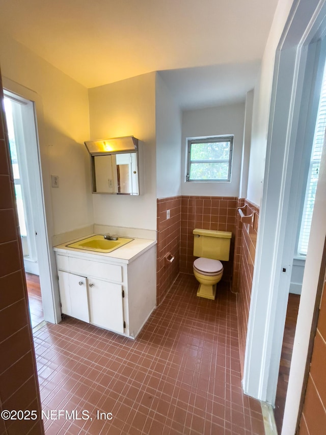 417 N 3rd St, Palatka, FL 32177 - half bath with vanity, tile walls, wainscoting, toilet, and tile patterned floors