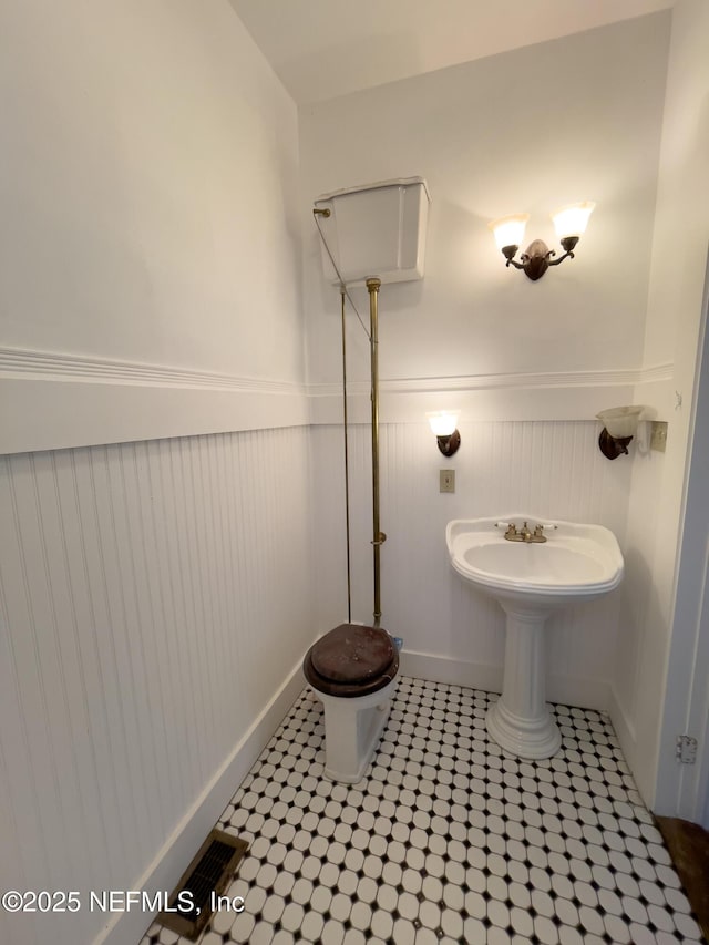 417 N 3rd St, Palatka, FL 32177 - bathroom featuring wainscoting, tile patterned floors, and toilet