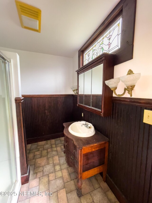 417 N 3rd St, Palatka, FL 32177 - full bathroom featuring wainscoting, vanity, wooden walls, stone finish flooring, and toilet