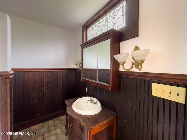 417 N 3rd St, Palatka, FL 32177 - bathroom featuring a wainscoted wall, vanity, wood walls, and stone finish floors