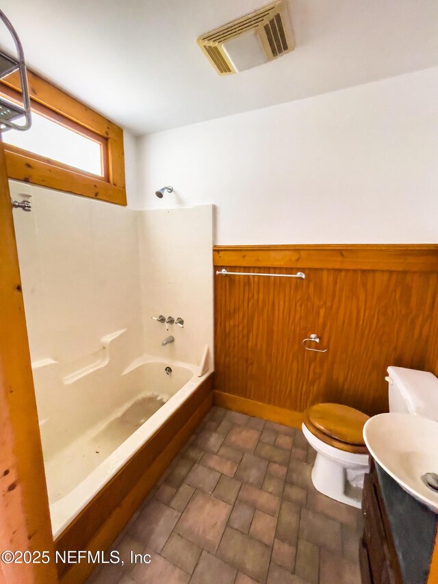 417 N 3rd St, Palatka, FL 32177 - bathroom featuring toilet, vanity, bathtub / shower combination, and stone finish flooring