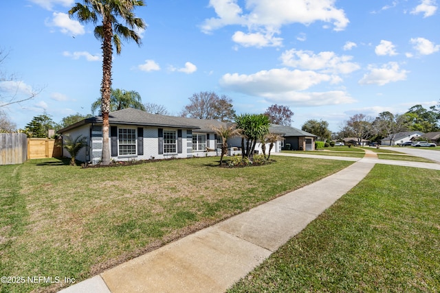 ranch-style home with a front lawn, an attached garage, fence, and brick siding