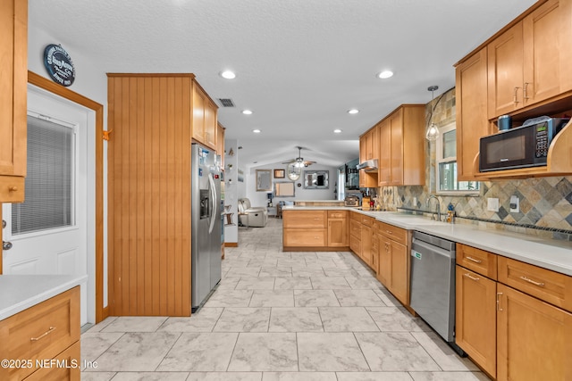 kitchen with stainless steel appliances, lofted ceiling, a peninsula, and light countertops