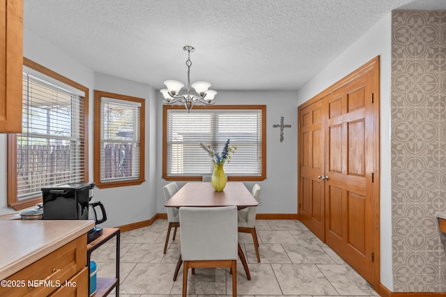 dining area featuring baseboards, a notable chandelier, and a healthy amount of sunlight