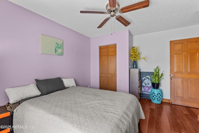 bedroom featuring a ceiling fan, wood finished floors, a closet, and a textured ceiling