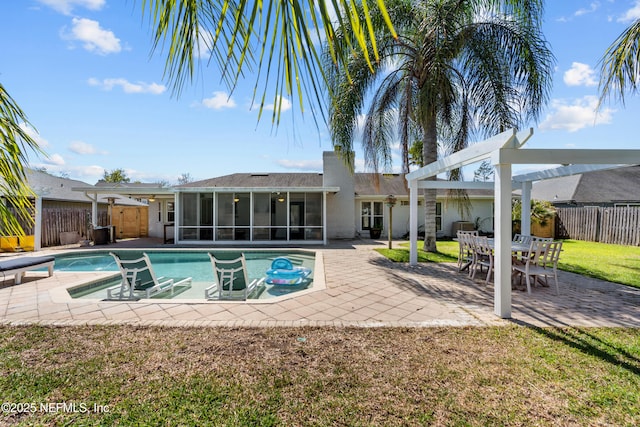 outdoor pool with a patio, a fenced backyard, and a sunroom