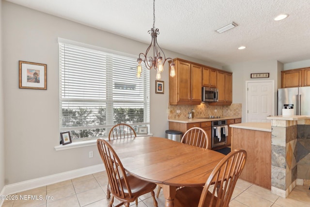 dining space with visible vents, a notable chandelier, a textured ceiling, light tile patterned floors, and baseboards