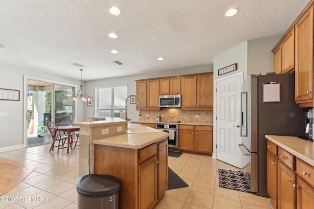 kitchen featuring brown cabinetry, backsplash, stainless steel appliances, and a sink