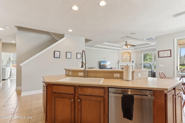 kitchen featuring open floor plan, dishwasher, an island with sink, light tile patterned flooring, and a sink