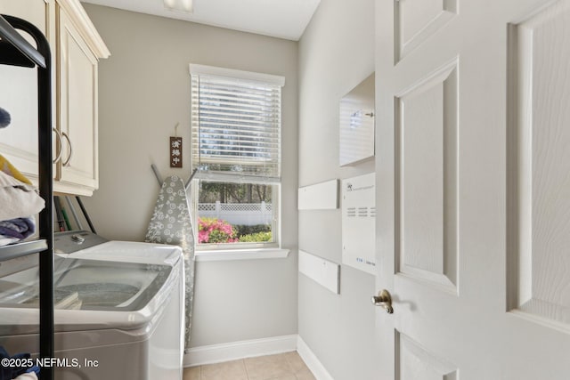 washroom with separate washer and dryer, light tile patterned floors, cabinet space, and baseboards