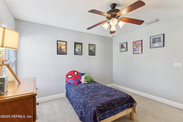 bedroom with visible vents, baseboards, light colored carpet, and a textured ceiling