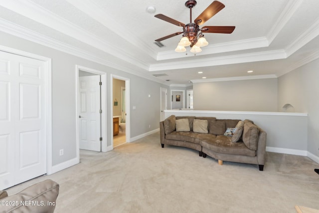 living area with light carpet, a raised ceiling, and ceiling fan