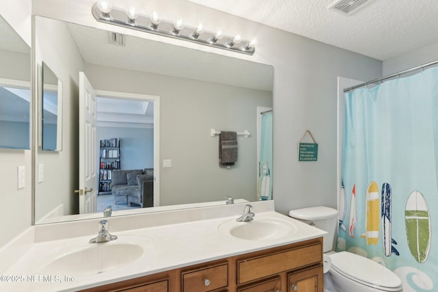 bathroom featuring a sink, visible vents, a textured ceiling, and double vanity