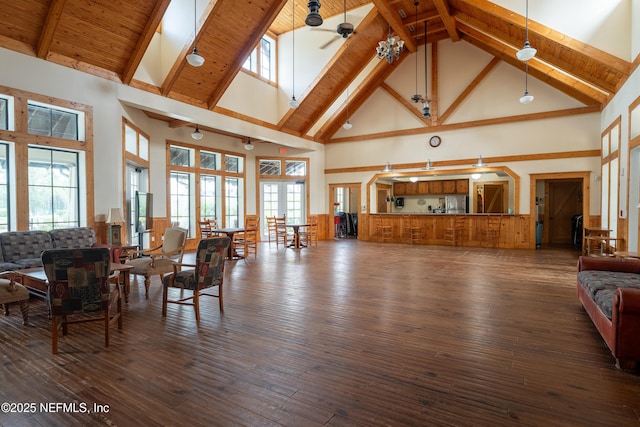 living room featuring beam ceiling, wood ceiling, ceiling fan, and dark wood-style flooring