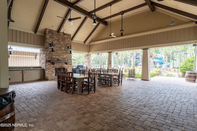 view of patio / terrace with ceiling fan, outdoor dining area, and an outdoor stone fireplace