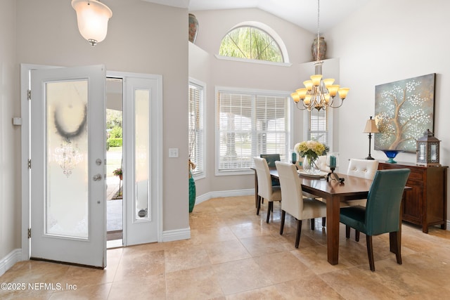 dining room featuring an inviting chandelier, light tile patterned floors, baseboards, and high vaulted ceiling