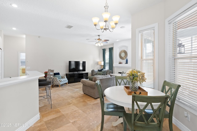 dining area featuring a wealth of natural light, visible vents, baseboards, and ceiling fan with notable chandelier